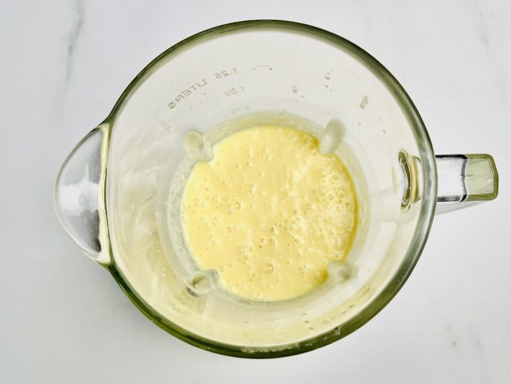 No liquidificador, o leite, uma lata de milho-verde e o amido de milho batidos.