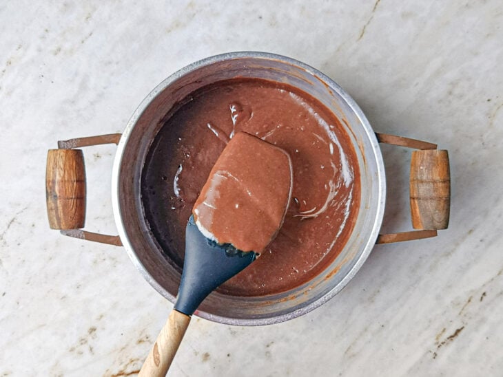 Creme atingindo o ponto de escorrer em fio da espátula.