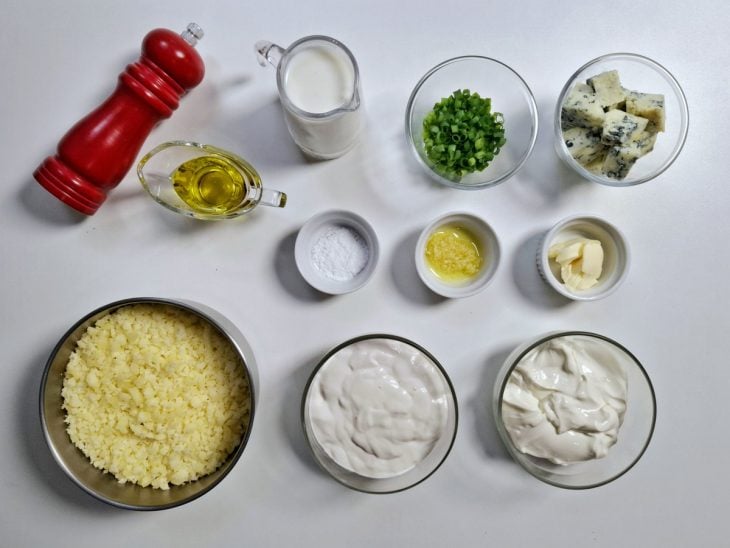 Ingredientes para produzir a receita de creme de queijo separados em uma bancada.