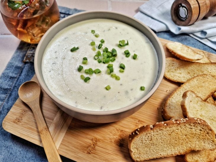Creme de queijo finalizado com cebolinha e servido com torradas.