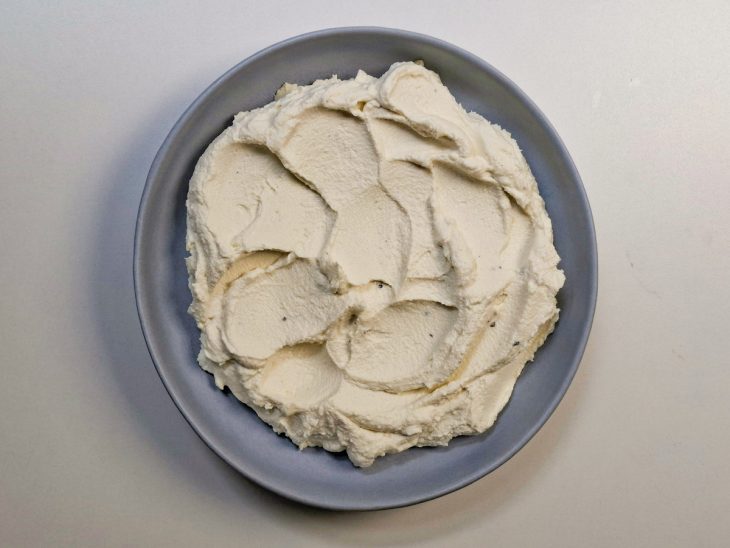 Creme espalhado em travessa rasa com colher.