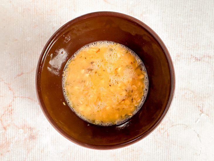 Massa de crepe de aveia sendo misturada com ovo e temperos até ficar homogênea.