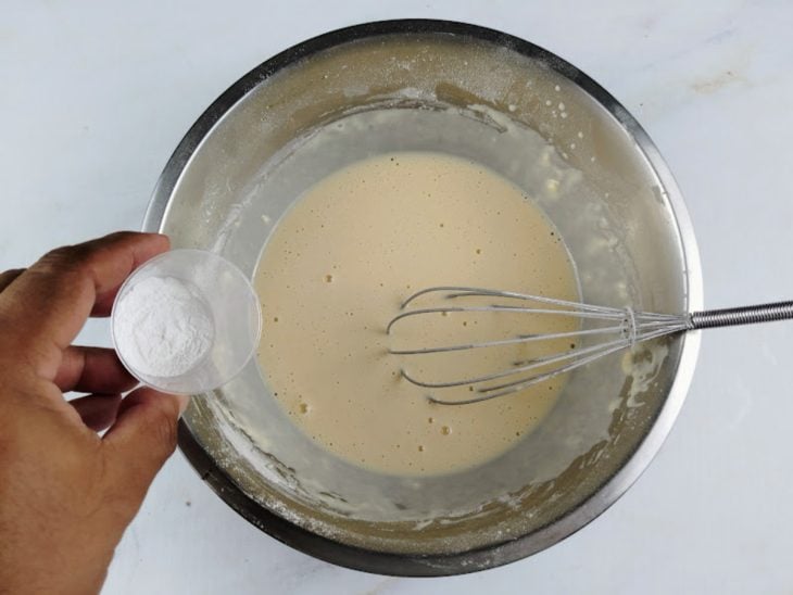 Um fouet e uma tigela com os ingredientes da massa misturados.