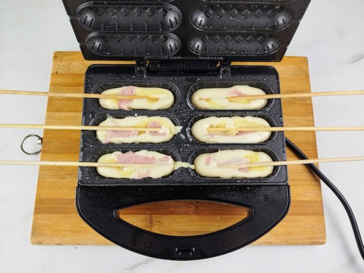 Uma crepeira com a massa, o recheio e os palitos.