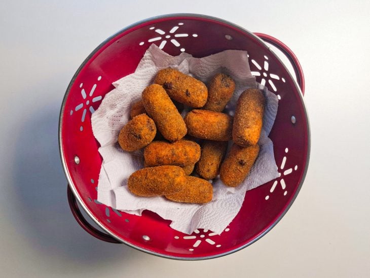 Croquetes fritando em óleo quente até dourar.