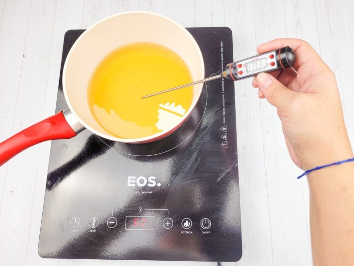 Panela com óleo e um cronômetro culinário verificando a temperatura do óleo.