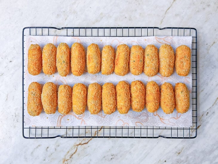 Croquetes escorrendo em papel toalha.