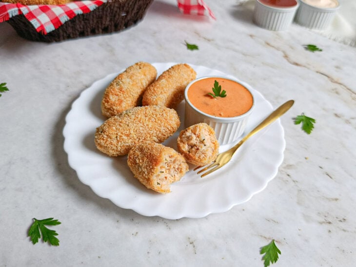 Croquetes prontos e servidos com molho.