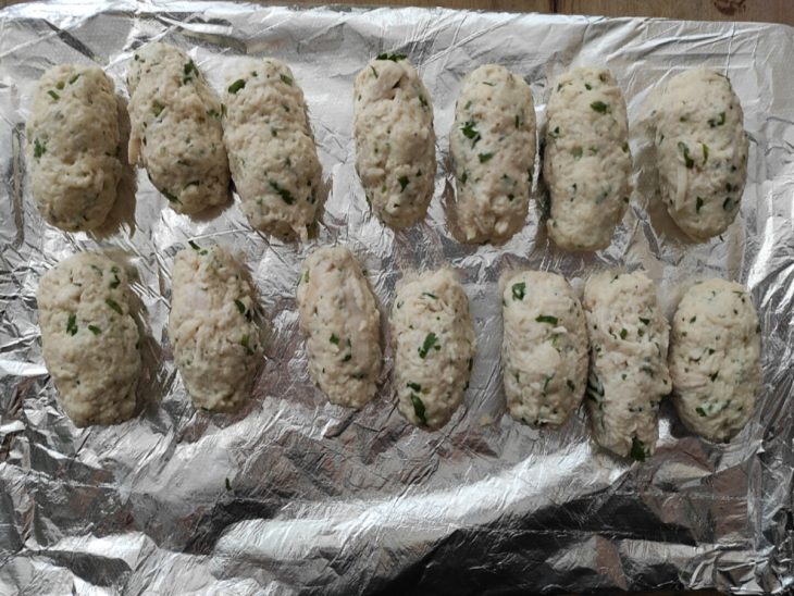 Croquetes moldados e acomodados sobre um pedaço de papel-alumínio.