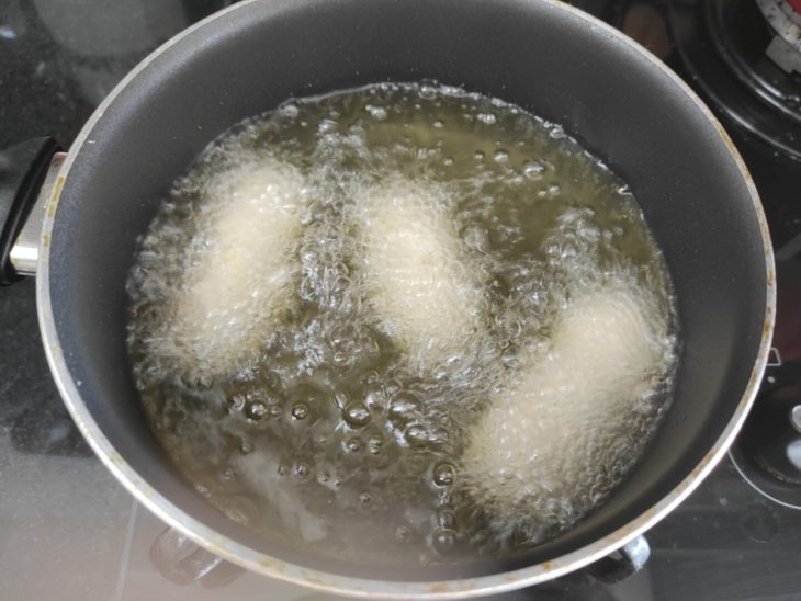 Croquetes de frango em óleo quente na panela.