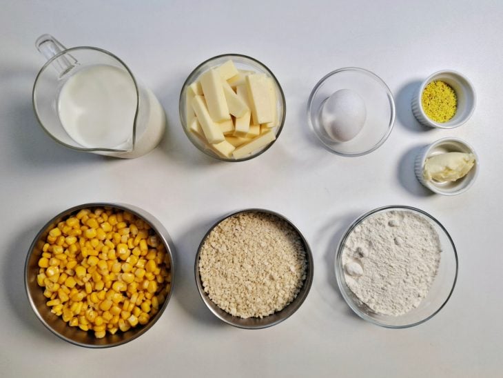 Ingredientes para a receita de croquete de milho reunidos em uma bancada.