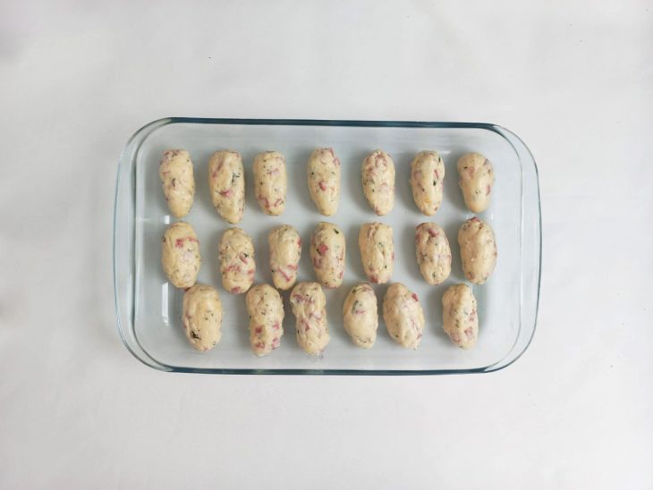 Um refratário com os croquetes modelados.