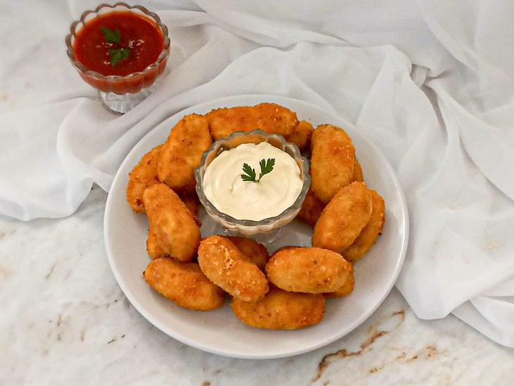 Um prato com croquetes de mortadela.