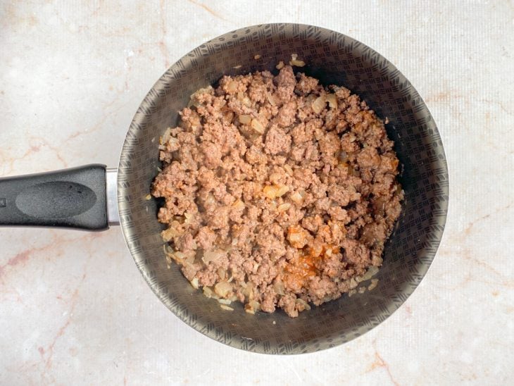 Panela com a carne temperada e a adição de extrato de tomate.