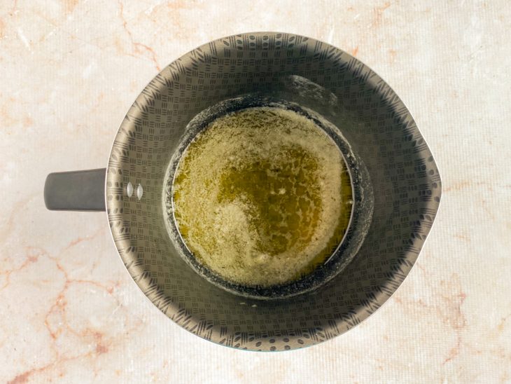 Sal e pimenta-do-reino adicionados nos ingredientes derretidos na leiteira.