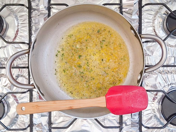 Manteiga derretida com azeite, na panela.