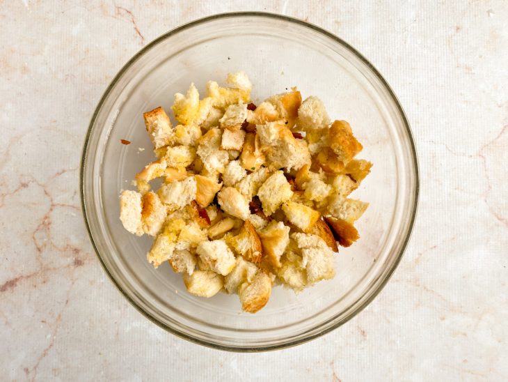 Numa tigela, o pão regado com a mistura temperada de óleo e manteiga.