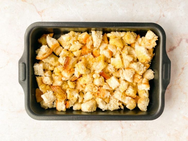 Crountons espalhados numa assadeira, prontos para irem ao forno.
