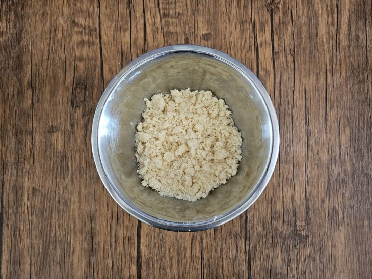 Um recipiente contendo a mistura de farinha, açúcar e manteiga.