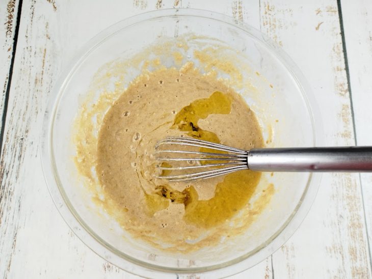 Massa homogênea sendo finalizada com fermento e frutas secas.