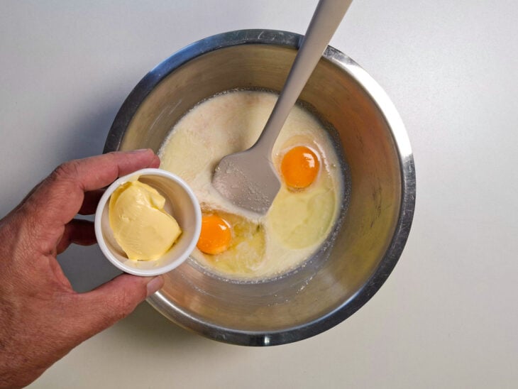 Ovos, margarina e leite em pó incorporados à mistura líquida, formando uma base homogênea para a massa.