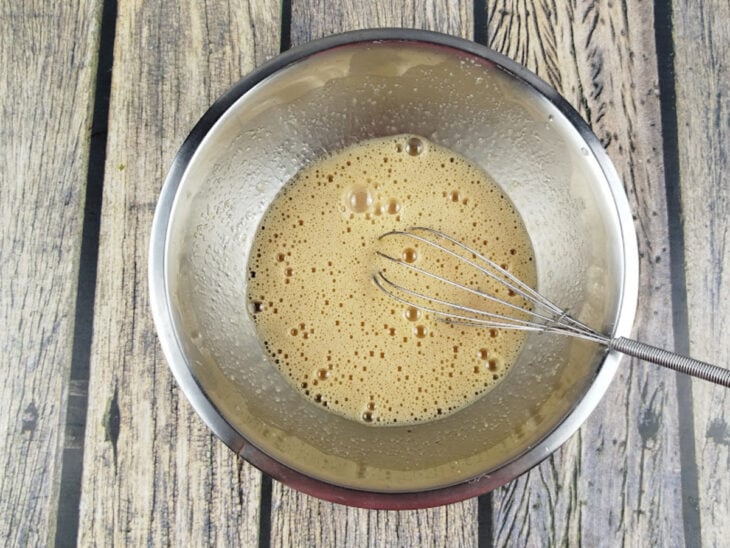 Ingredientes batidos numa tigela com auxílio de um fouet.