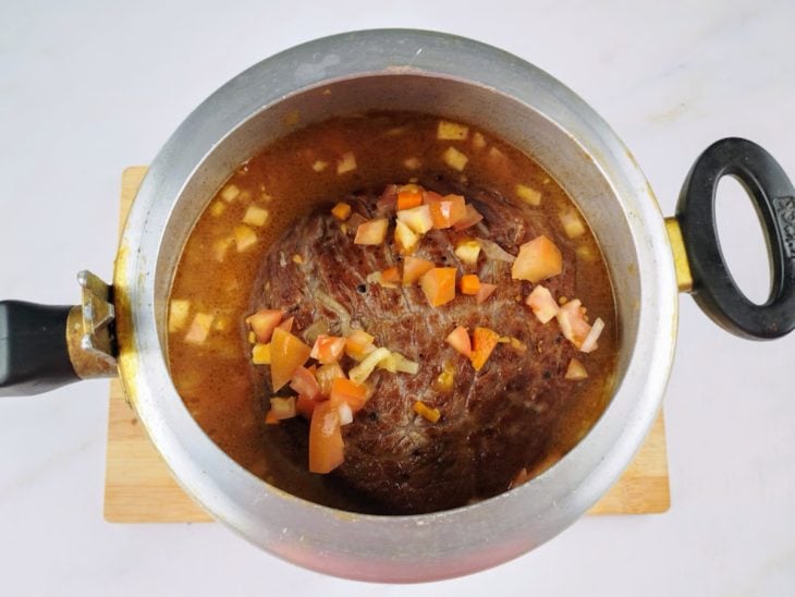 Cupim, temperos e água adicionados na panela de pressão.