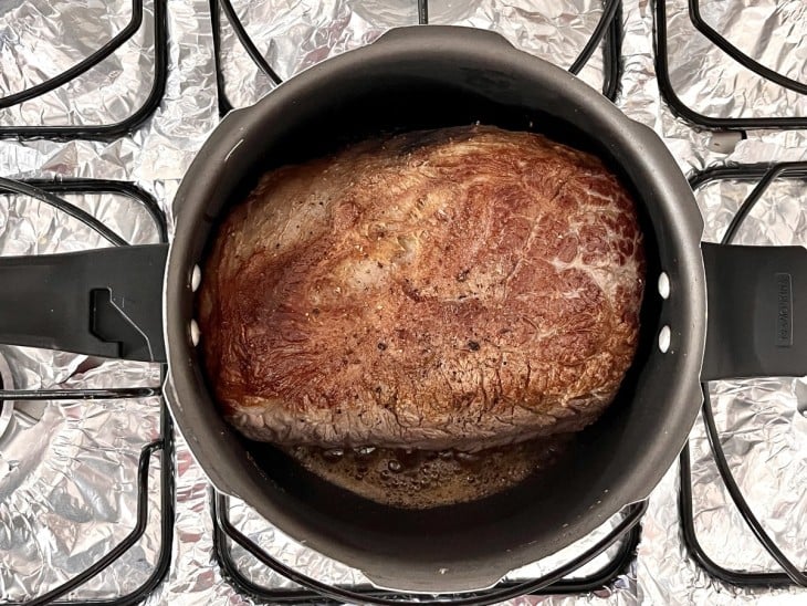 Panela de pressão com peça de cupim dourada.