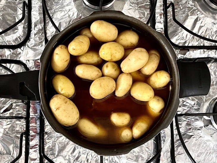 Batatas dentro da panela de pressão junto com o cupim.