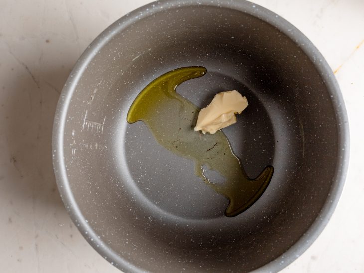 Manteiga e azeite em uma panela de pressão.