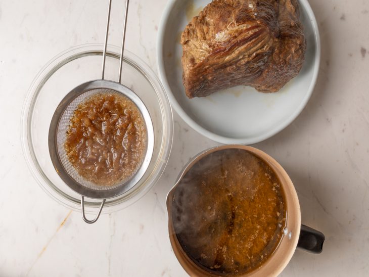 Peça de cupim reservada em um prato e cebola coada do caldo do cozimento.