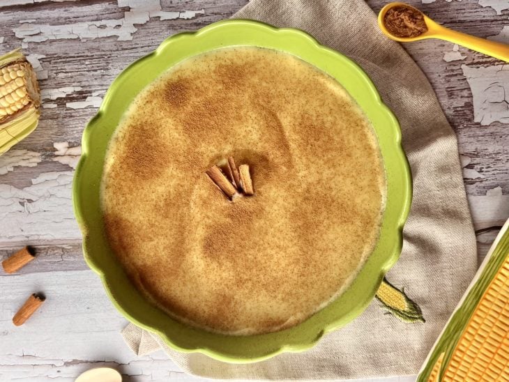 Curau de milho com leite condensado com canela polvilhada por cima em um refratário.