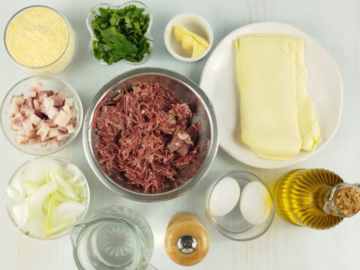 Ingredientes organizados na bancada, com ovos quebrados visíveis.