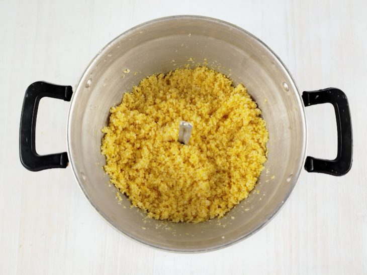 Cuscuz sendo colocado na parte superior da cuscuzeira.