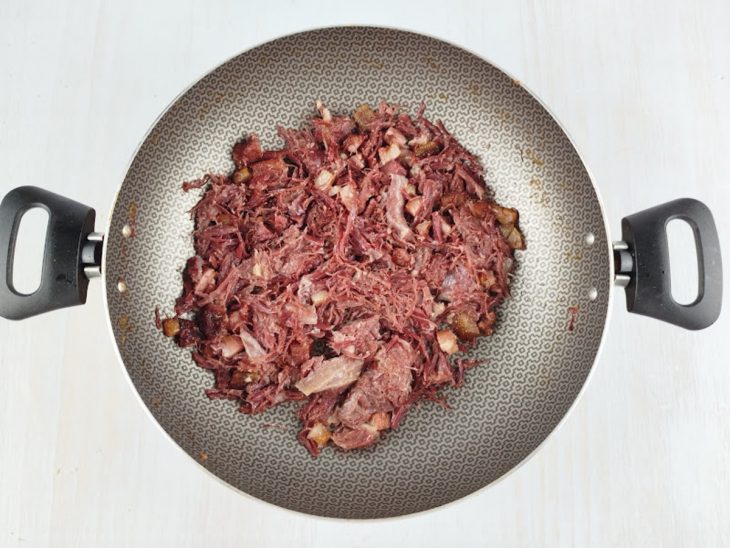 Bacon e charque fritos até dourar, ainda na mesma panela.