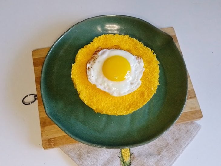 Um prato contendo cuscuz com ovo.