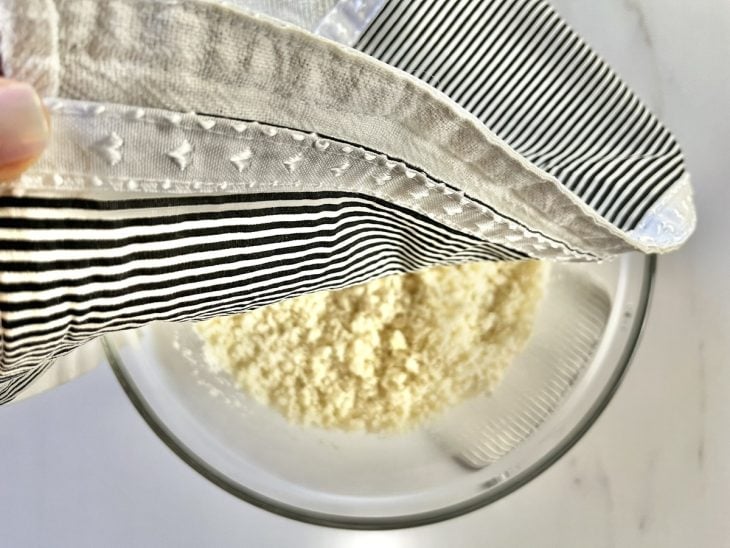 Um recipiente com massa de cuscuz de arroz coberto com um pano.