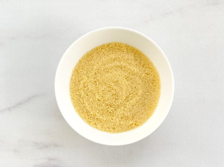 Cuscuz com caldo de legumes em uma tigela.