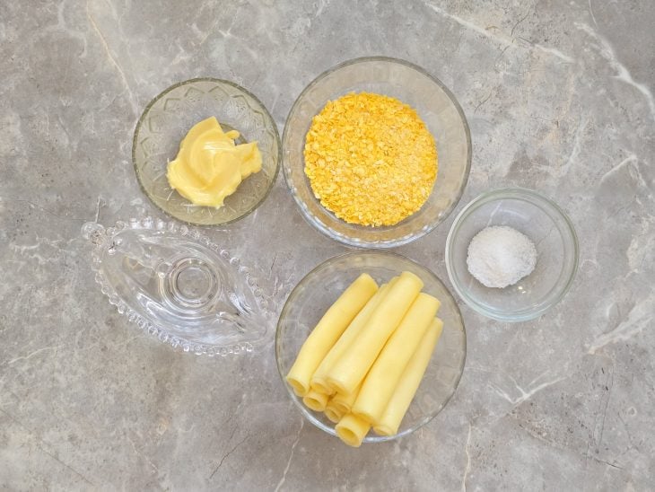 Ingredientes organizados com flocão de milho, água e queijo na bancada.