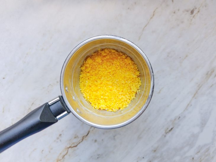 Camada de flocão sendo colocada na cuscuzeira.