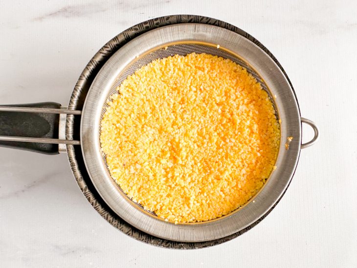 Peneira colocada sobre a panela com água.