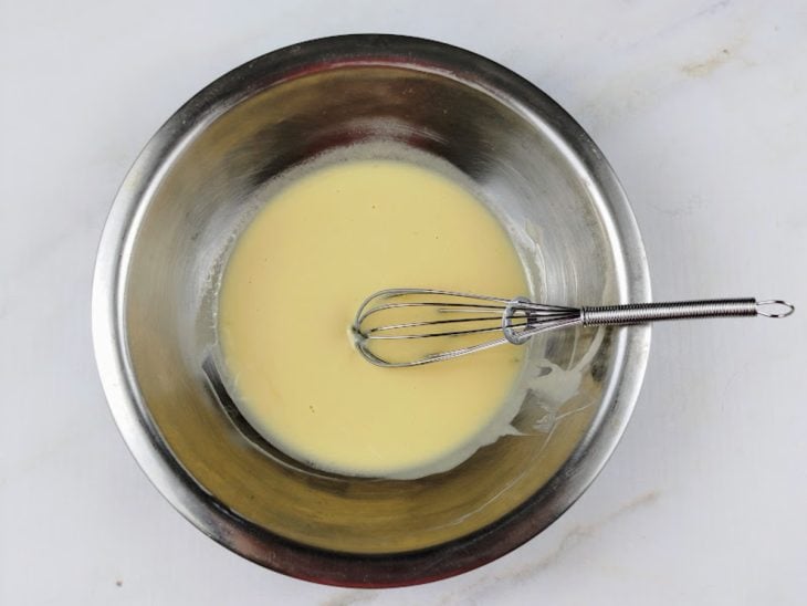 Iogurte, ovo, baunilha e mel batidos em um recipiente de alumínio.