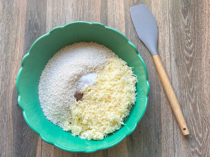 Uma tigela com tapioca, queijo, sal e pimenta.
