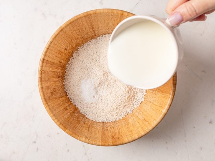 Tapioca granulada e leite quente em uma tigela grande.