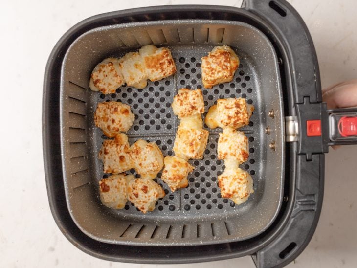 Dadinhos de tapioca dourados dentro da airfryer.