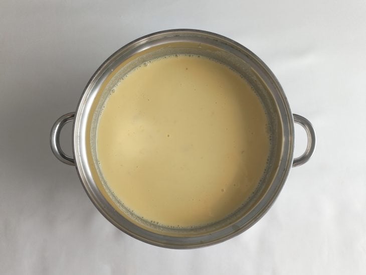 Água gelada, leite condensado e creme de leite adicionados na panela.