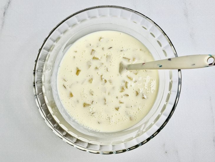 Abacaxi acrescentado na mistura de creme de leite e leite condensado.