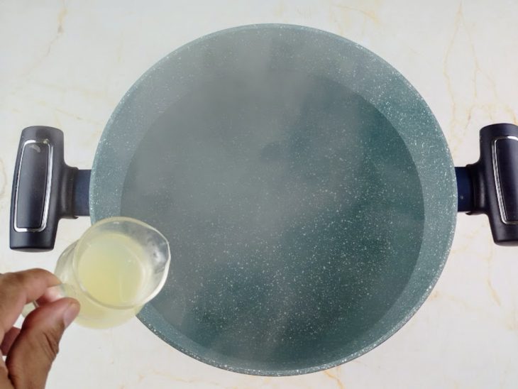 Água fervente numa panela com suco de limão espremido para ser adicionado.