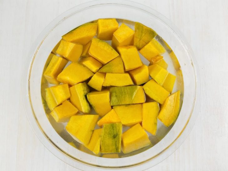 Cubos de abóbora submersos em água.