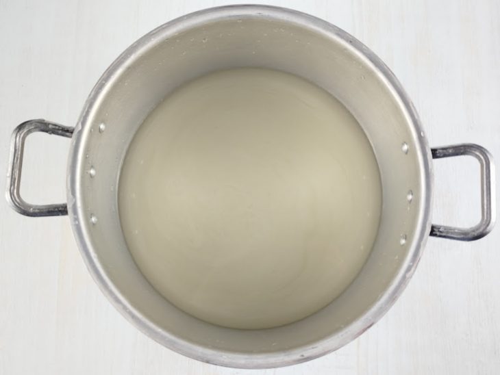 Açúcar dissolvido na água em panela larga.